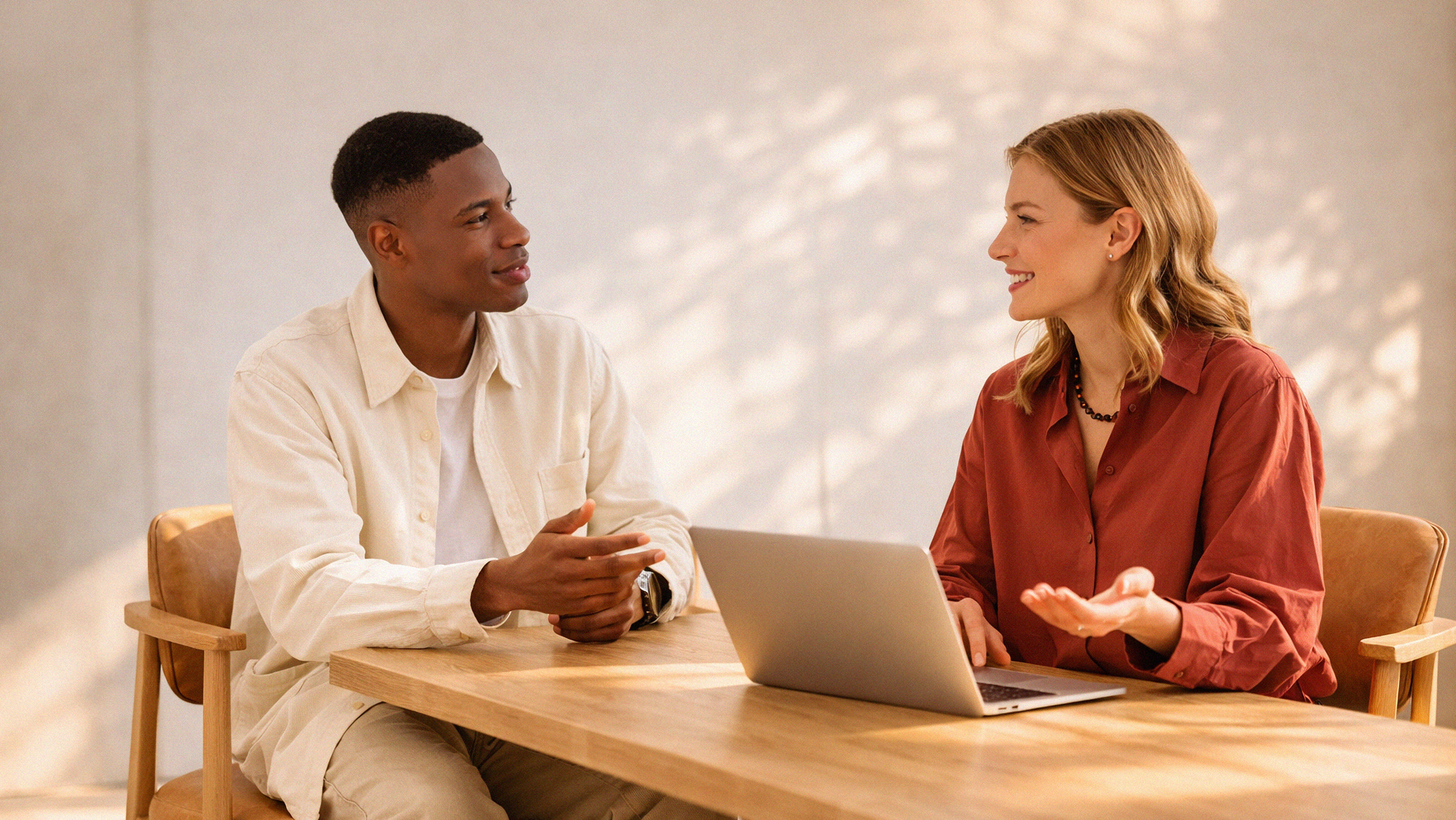 Two people at office desk with laptop